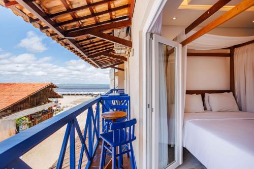 a balcony with a bed and a view of the beach at Vila Gallina Pousada in Jericoacoara