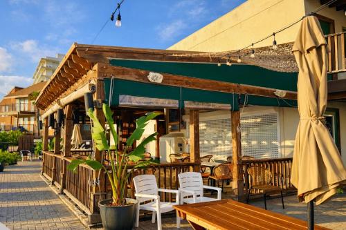 a patio with a table and chairs and an umbrella at Palms Resort & Cafe on the Beach in South Padre Island
