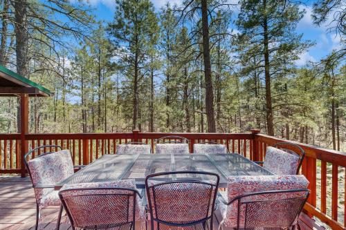 a wooden deck with a table and chairs on it at Wild West Wonder in Pinetop-Lakeside