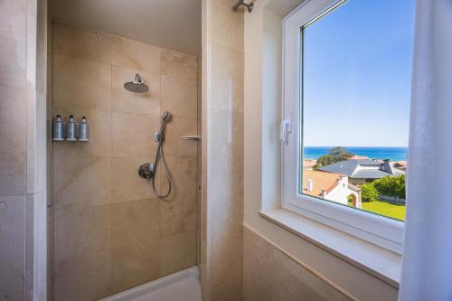 a bathroom with a shower and a window at Gran Hotel Suances in Suances