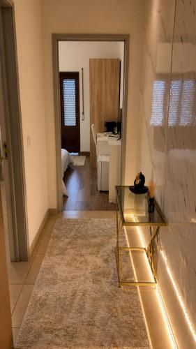 a living room with a glass table and a bathroom at Albani Hostel in Palmela