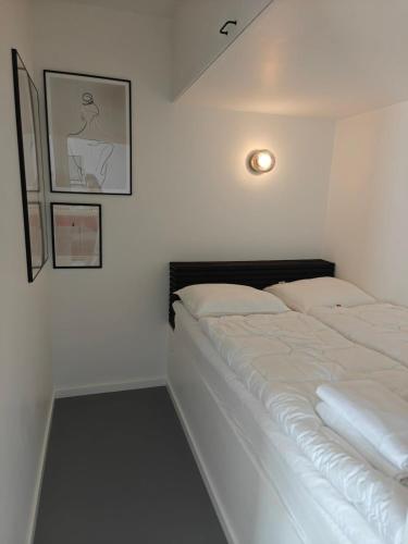 a bedroom with a bed and a picture on the wall at Sea view Ella - Hejlsminde Badehotel in Hejlsminde