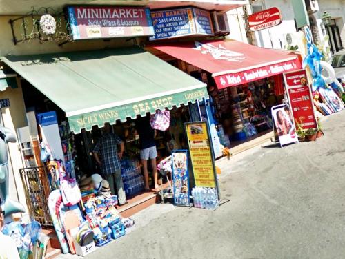 a man standing in front of a store in a street at Villa Arianna B&B in Taormina