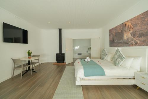 a bedroom with a bed and a table and a television at theLAB BLUE in Franschhoek