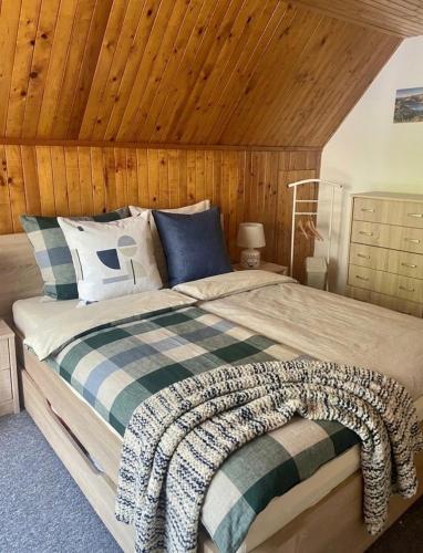 a bedroom with a large bed with a wooden ceiling at Domček u Ferka in Dedinky