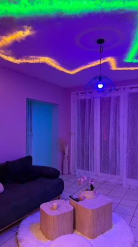 a living room with purple and green lights on the ceiling at Romantic Suite with Private Jacuzzi in Noyon