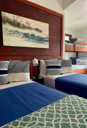 a room with three beds and a painting on the wall at Kalani Hawaii Private Lodging in Pupukea