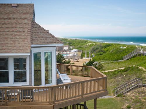 a large deck with a view of the ocean at The Sanderling in Duck