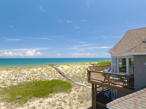 a view of the beach from the balcony of a house at The Sanderling in Duck
