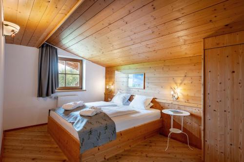 ein Schlafzimmer mit einem Bett in einer Holzhütte in der Unterkunft Hotel Frohnatur in Thiersee