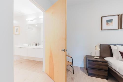 a bedroom with a bed and a bathroom with a tub at Joinery North in Charlotte