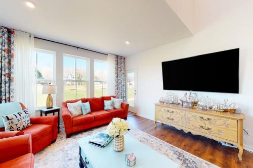a living room with red furniture and a flat screen tv at Bishop's Landing -- 31186 VICTOR RD in Millville