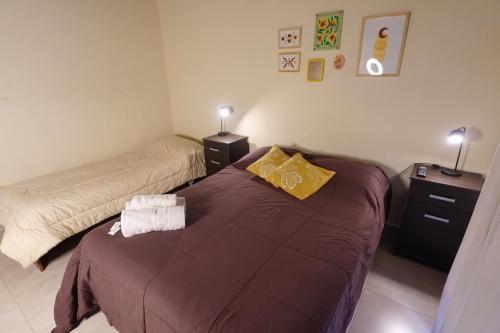 a bedroom with two beds and two night stands at El Retorno Hostel in Puerto Madryn