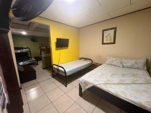 a room with two beds and a tv in it at Hospedaje Doña koko in Puerto Limón