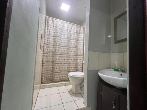 a bathroom with a shower and a toilet and a sink at Hospedaje Doña koko in Puerto Limón