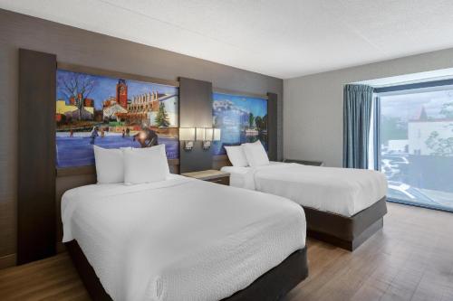 a hotel room with two beds and a large window at Best Western Belleville in Belleville