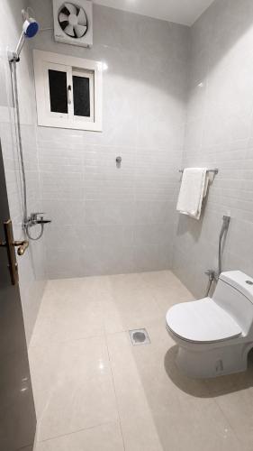 a white bathroom with a toilet and a window at أرياف سويت in Al Baha