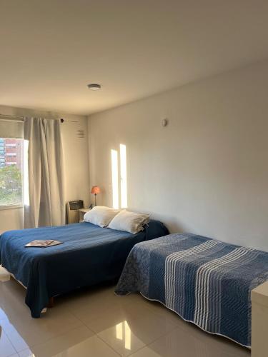 a bedroom with two beds and a window at Blandengues 55 in Bahía Blanca