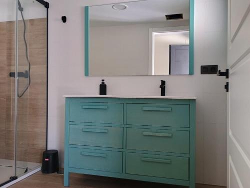a bathroom with a green dresser and a mirror at A de Amancio in Sayáns