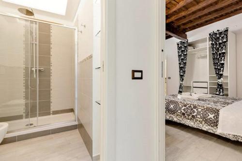 ローマにあるCasa Vacanze Colosseum by Serenaの白いバスルーム(ベッド1台、シャワー付)