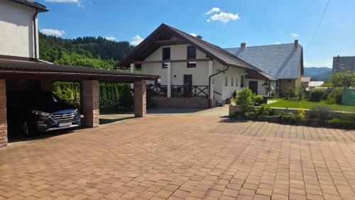 a driveway with a car parked in front of a house at Ubytovanie u Adama in Oščadnica