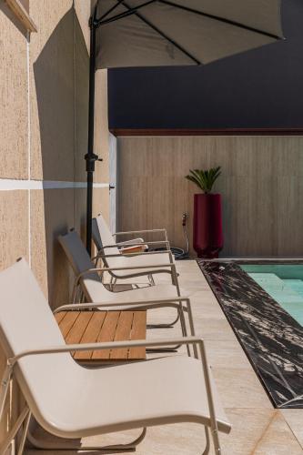 a row of chairs sitting next to a swimming pool at Oasis Paradise Pool Villa in Durrës