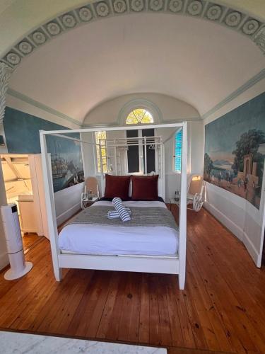 a bedroom with a white bed with red pillows at La maison de Blandine in Honfleur
