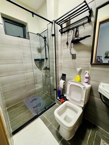 a bathroom with a shower and a toilet and a sink at Cozystays by Vee Near JKIA in Nairobi
