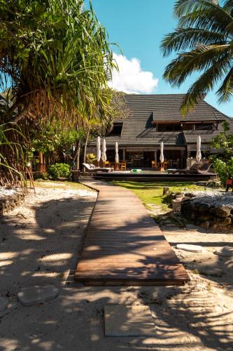 a path in front of a house with palm trees at Green Lodge Moorea in Teavaro