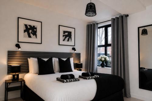a bedroom with a large bed with black and white pillows at Newcastle City Centre 2BR, Near Central Train Station in Newcastle upon Tyne