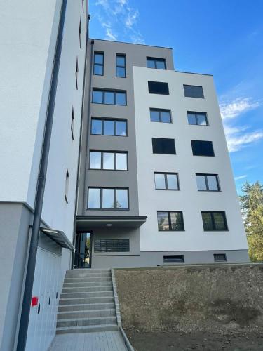 a white building with stairs leading up to it at Apartmán Formula Trenčín in Trenčín