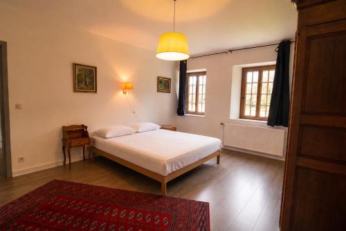 a bedroom with a white bed and a window at Gîte du Château de Spontin - 7a chaussée de Dinant - 5530 Spontin in Spontin