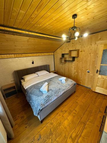 a bedroom with a large bed in a wooden ceiling at Grey House in Vorokhta