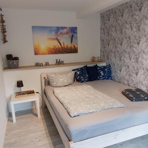 a small bedroom with a bed and a table at Das Zimmer - Bauernhof-Nordsee-Urlaub in Norderfriedrichskoog