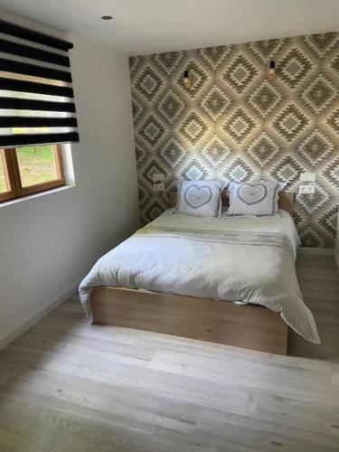 a bedroom with a bed with a wall at L'erable in Montlay-en-Auxois