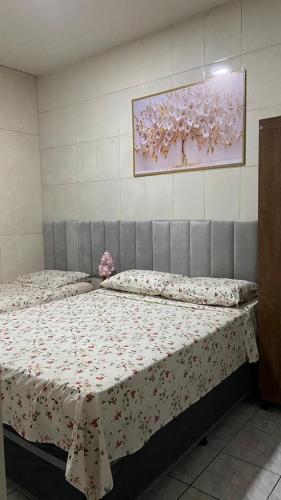 a bedroom with two beds and a painting on the wall at Central APE Diamantina in Diamantina