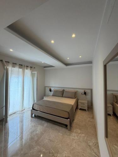 a bedroom with a bed and a large window at Tropea Olympus Apartments in Santa Domenica