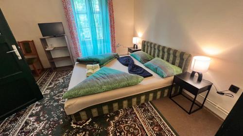 a bedroom with two beds with green pillows at Fogadó a Kóbor Macskához in Kőszeg