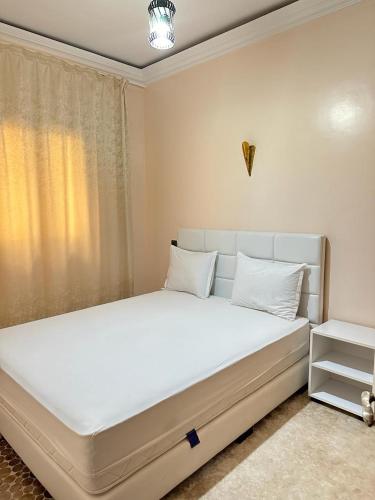 a bedroom with a large white bed with white pillows at Jannat Résidence in Ouarzazate