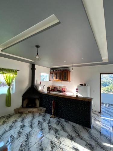 a kitchen with a stone floor and a fireplace at Cataventooo hospedagens in Miguel Pereira
