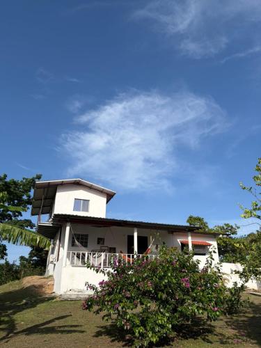 a white house on a hill with a bush at Senderos de Ana in San Carlos