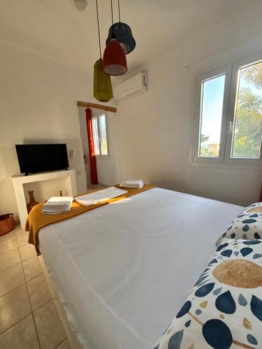 a bedroom with a bed with a desk and a television at 7olives Golden Boutique Apartment in Kastraki