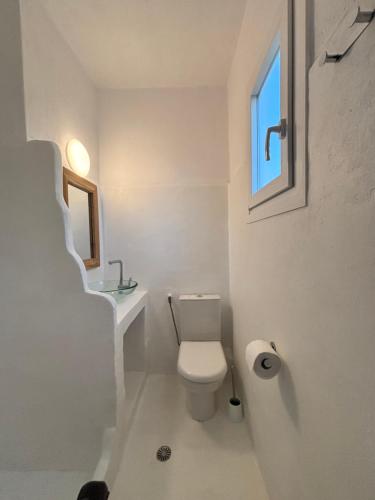 a bathroom with a toilet and a sink and a window at 7olives Golden Boutique Apartment in Kastraki