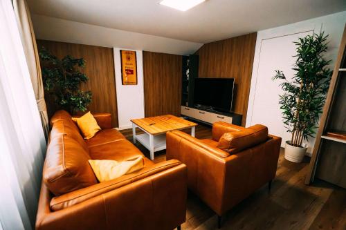 a living room with two leather couches and a table at Cozy Apartment - Stunning Views in Brienz