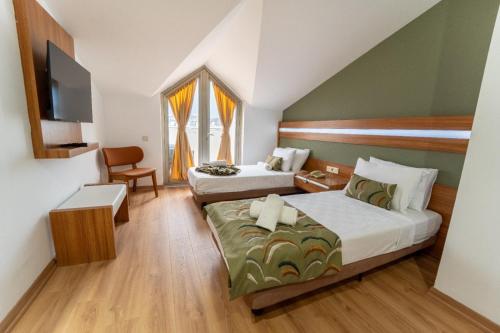 a hotel room with two beds and a tv at La Brisa Hotel in Antalya