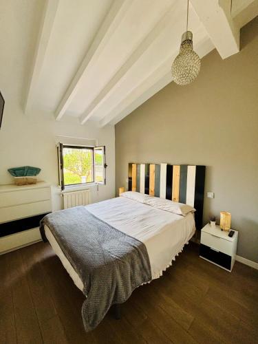 a bedroom with a large bed and a window at La Casita cerca de la playa in Santander