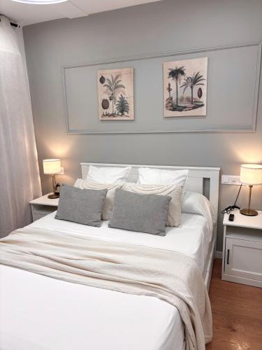 a bedroom with a large white bed with two lamps at Alojamiento D'Moda in Ribadeo