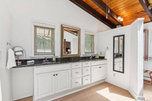 a bathroom with white cabinets and a wooden ceiling at Sues Lake House in Buford