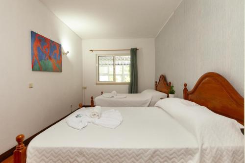 a bedroom with two beds with white sheets and a window at Praia da Luz Coast Flat in Luz