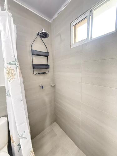 a bathroom with a shower with a toilet and a window at Caribe 102-1 in San Andrés